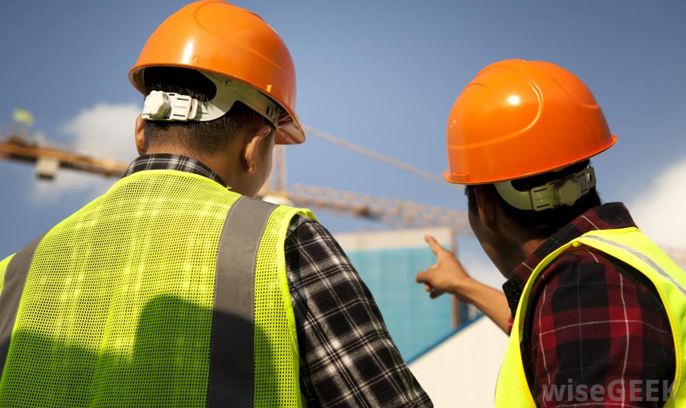 two-men-in-orange-hard-hats-pointing-at-bridge